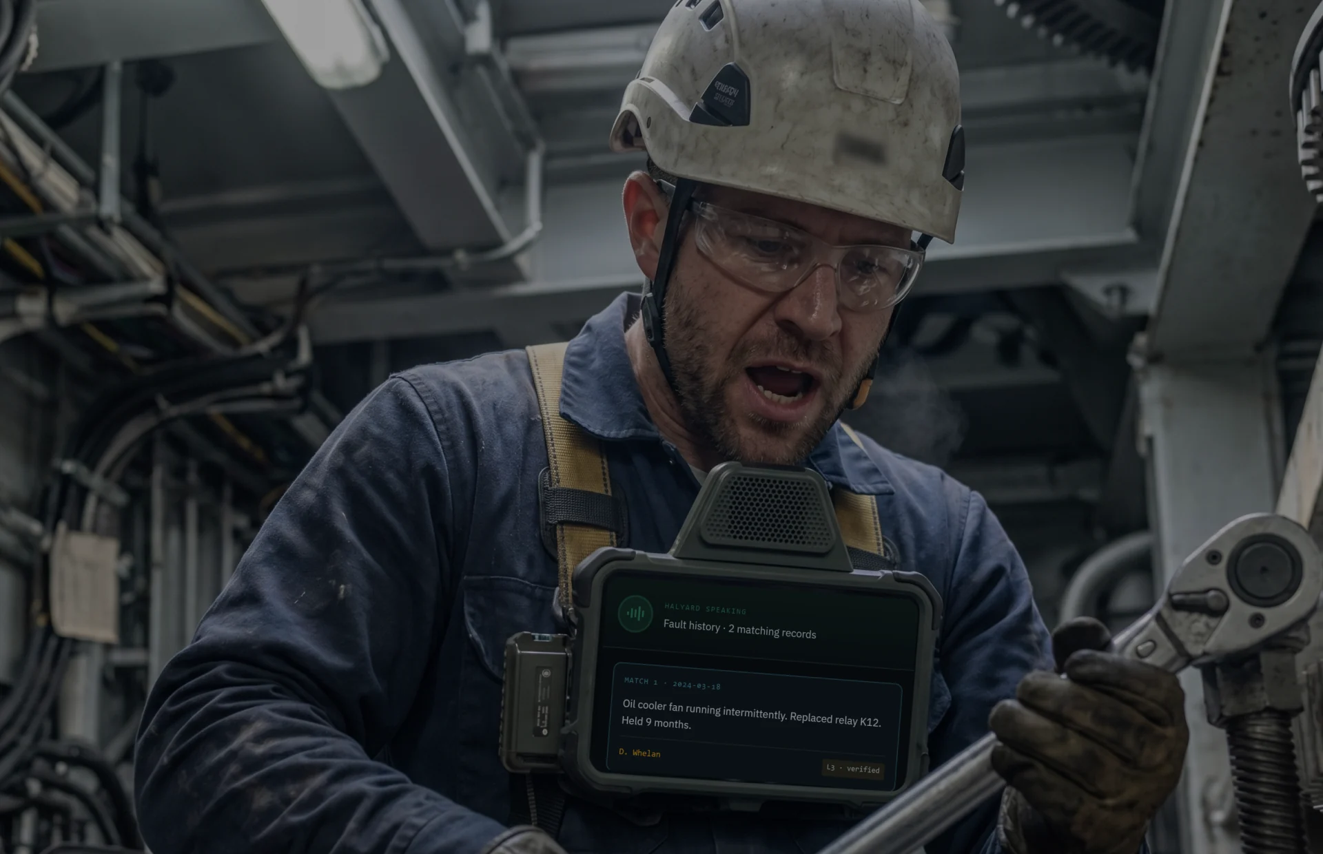 Halyard cover — a wind-turbine technician using the voice-first Halyard field agent, its screen showing fault-history records.